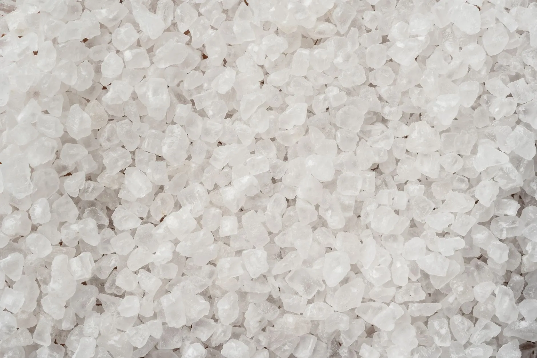 A close view of hard, clear coarse sea salt crystals